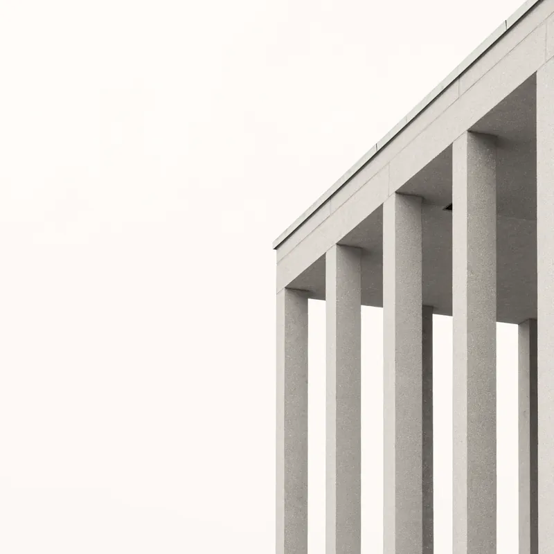 Détail d’une colonnade blanche en contre-plongée.