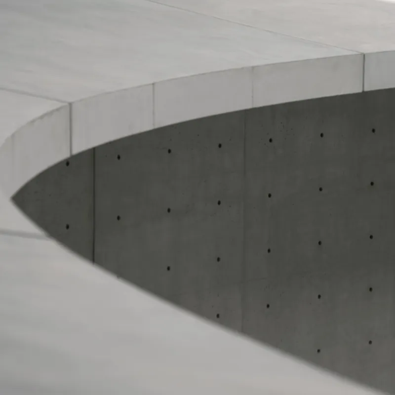Détail d’une dalle de béton courbe au-dessus d’un mur.